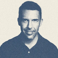 A black and white photo of a man smiling.